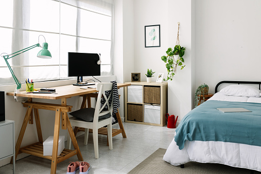 Cozy interior teenage person room with bed and desk