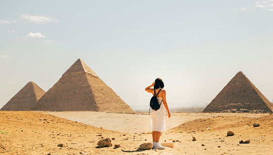 woman posing in front of the pyramids of egypt in cairo in the morning