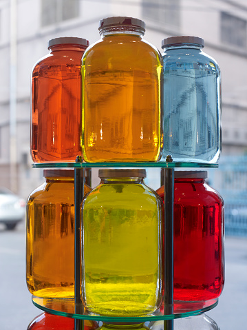 Colorful jars stacked in a shop window, No people.