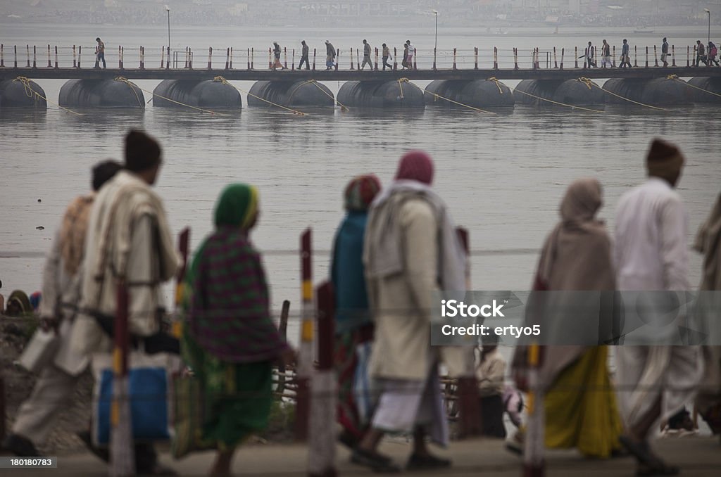 Hindu Devotees walk Hindu Devotees walk across a bridge through heavy morning fog during the Kumbh Mela in Allahabad in India. Awe Stock Photo