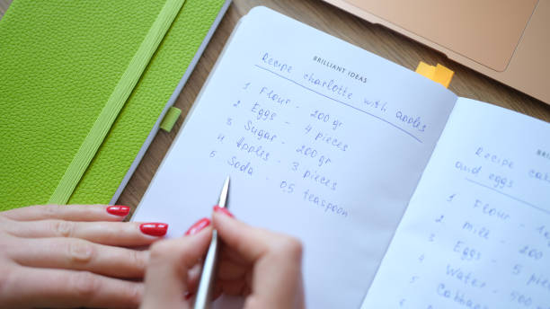 istock Woman writes down recipe for apple charlotte 1801856287