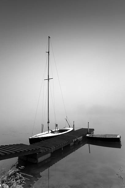 Sailboat in hazy sunrise stock photo