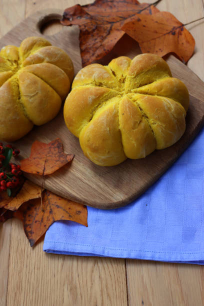 istock Orange pumpkin shaped  buns ontable with autumnal leaves 1801873344
