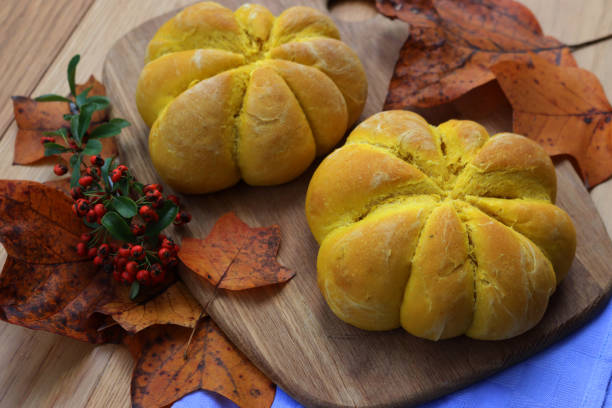 istock Orange pumpkin shaped  buns ontable with autumnal leaves 1801873361