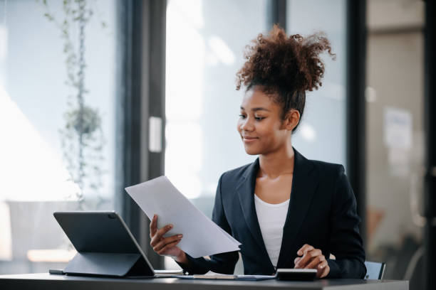 istock Beautiful Asian woman using laptop and tablet while sitting at her working place. Concentrated at work. 1801874434