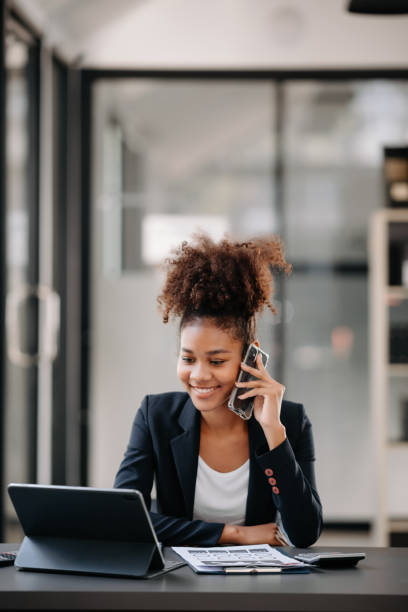 istock Beautiful Asian woman using laptop and tablet while sitting at her working place. Concentrated at work. 1801874466