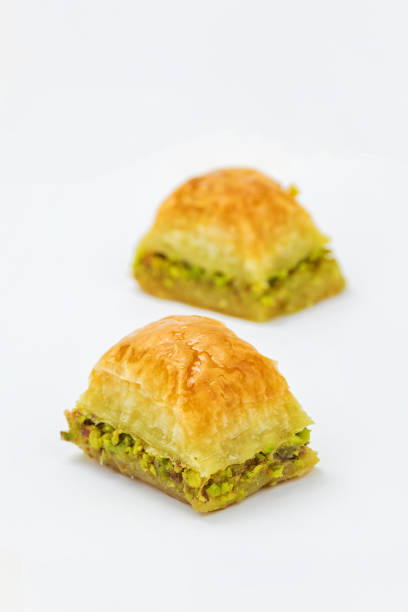 istock Baklavas with pistachios in selective focus on white background. 1801902419