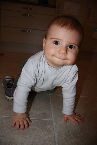 pequena bebé menino - baby tile crawling tiled floor imagens e fotografias de stock