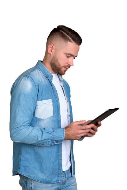 istock Young man looking at tablet in hands, isolated over white background 1801919577
