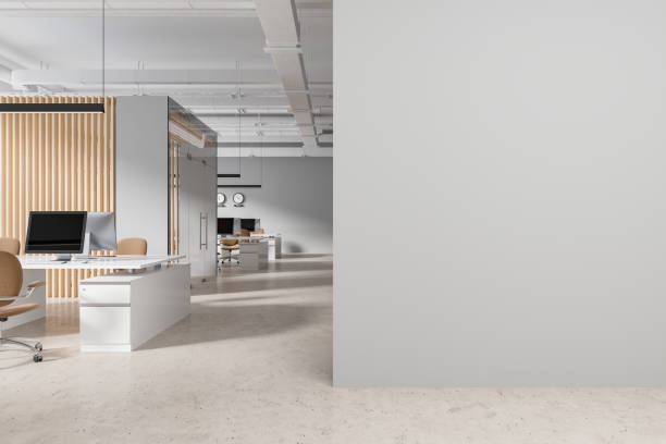 istock Gray and wooden open space office with blank wall 1801939003