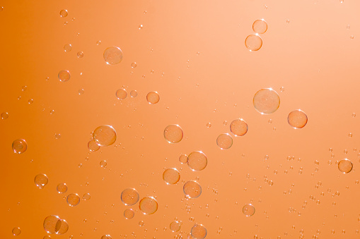Soap bubbles in the orange sky. Beautifully iridescent balls of soap foam in the air