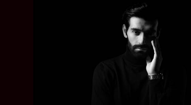 istock Pride thinking young business man Attractive bearded guy get confident Black and white photo Smart man stand in the dark room Confidence Cool man looking at camera copy space Business Fashion concept 1801982748