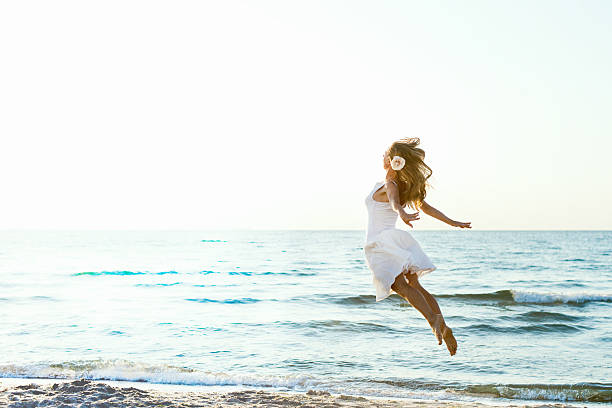 Happy Woman Jumping at the sea stock photo