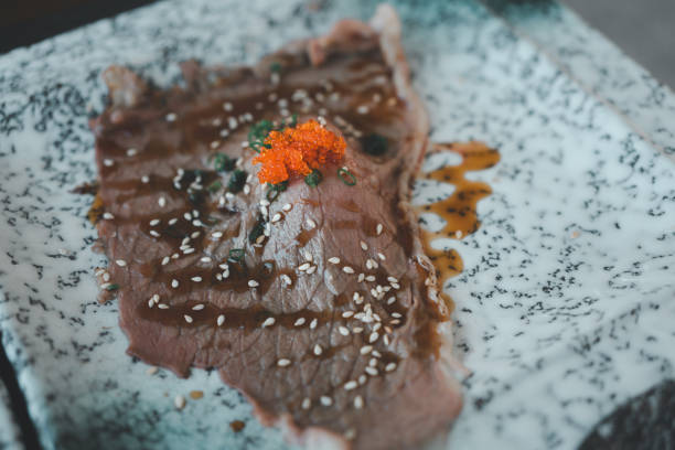 Grilled sushi wagyu beef with shoyu sauce on top with ebiko shrimp eggs and white sesame.