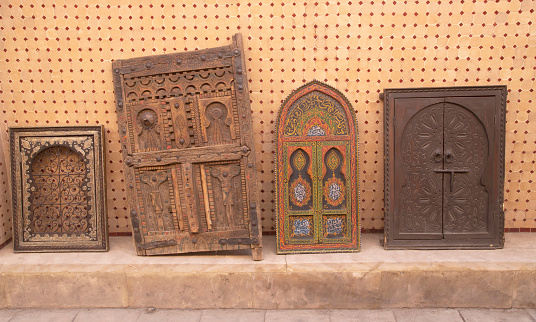 Old Moroccan carved interior wooden doors and pieces of furniture in street trade in Marrakesh, Morocco