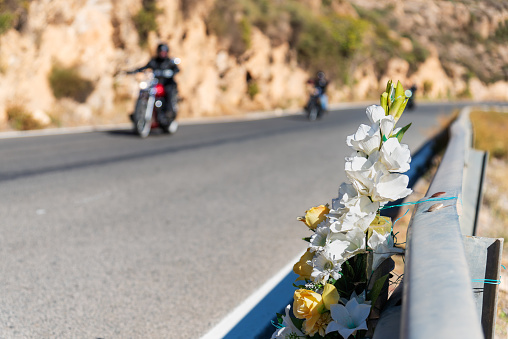 Bouquet of flowers tied to a highway guardrail in memory of a person who died in an accident.