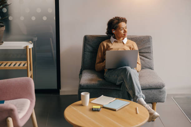 istock Pretty female freelancer working on laptop while sitting on modern coworking background 1802017179