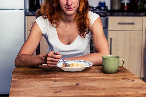 istock Woman eating cereal for breakfast 180202408
