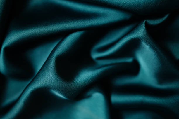 istock Emerald green silk or satin, draped fabric, elegant background. 1802048352