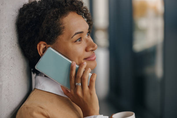 istock Close up of female freelancer is talking phone with client while standing on coworking background 1802058590