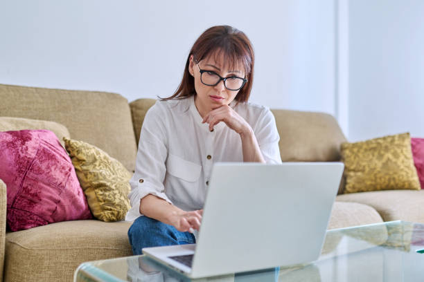 istock Serious middle aged woman working with laptop computer, in home office 1802060076