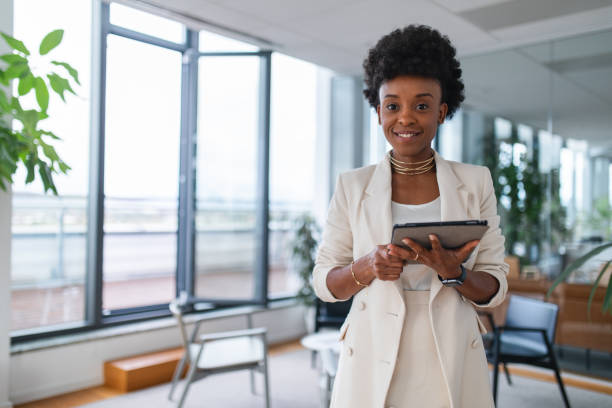 istock Young Black Female Corporate Manager With A Digital Tablet Looking At The Camera And Smiling 1802062221