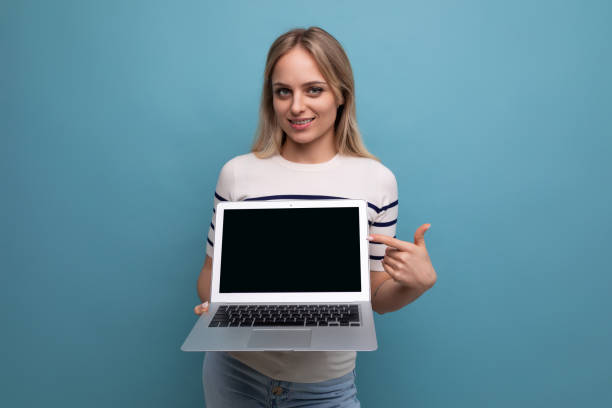 istock focused woman showing laptop screen with mockup on blue background 1802065421