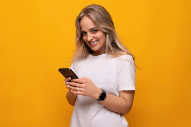 istock girl with a gadget sits on the Internet on an orange background 1802072428