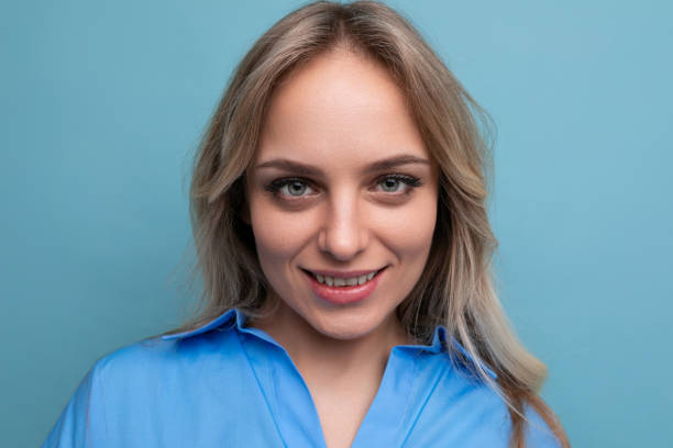 portrait of an adorable blonde young woman cutely closing her eyes on a blue background portrait of an adorable blonde young woman cutely closing her eyes on a blue background. cutely stock pictures, royalty-free photos & images