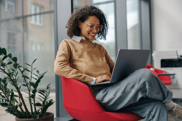 istock Smiling female manager using laptop while sitting on modern office background 1802074138