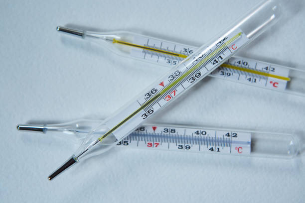 istock Three classic mercury thermometers with a scale of degrees Celsius lie on a clean white background. Concept of recovery from infection and coronavirus. 1802077388