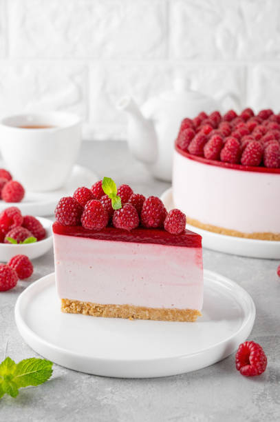 istock No baked raspberry cheesecake or raspberry cream mousse cake with jelly and fresh berries on top on a white plate on a gray concrete background. Summer cake. 1802116167