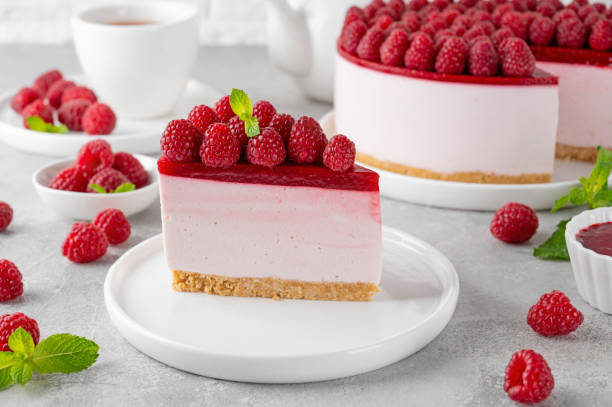 istock No baked raspberry cheesecake or raspberry cream mousse cake with jelly and fresh berries on top on a white plate on a gray concrete background. Summer cake. 1802116168