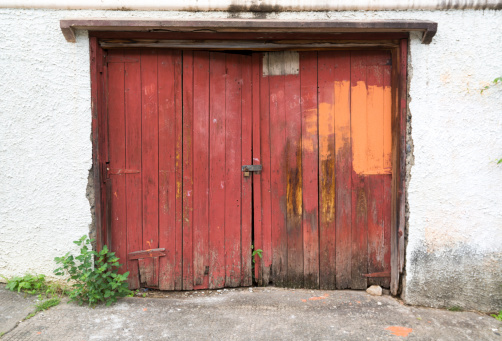 old damaged double red wooden garage door