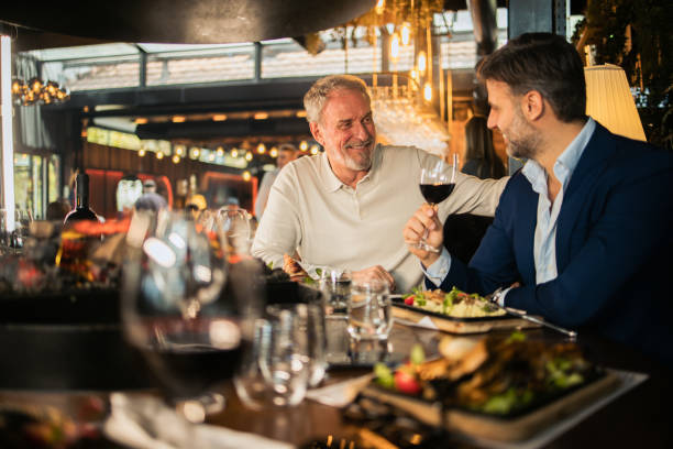 istock Two businessmen relaxing during a business lunch 1802150485