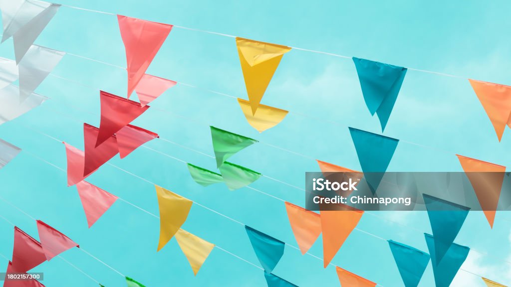 Fair flag bunting colorful background hanging on blue sky for fun fiesta party event, summer holiday farm feast celebration, carnival festival event, park or street festa design decoration Anniversary Stock Photo