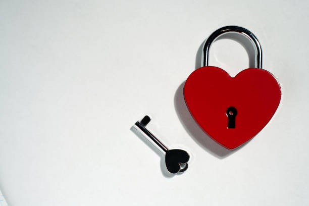 istock Metallic red heart shaped lock and key isolated on white background 1802157775