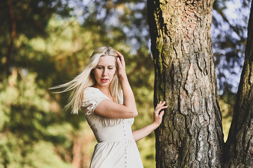 wellness and breathing, young woman with blond hair in a forest.