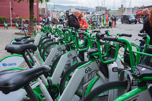 Bergen, Norway - June 22, 2023: A rack of electric bicycles, owned by Bergen City Bike, a bike sharing company, wait to be rented near the Bryggen.
