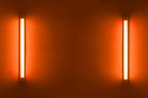 istock Two orange neon bulbs on white wall. Background texture of empty old wall with glowing orange neon bulbs. 1802207462