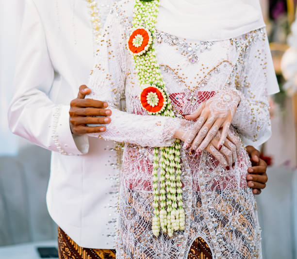 istock Romantic wedding couple photo. Javanese couple. Groom amd bride. Traditional java costume. Wedding in java. Black and white skin with henna tattoo. White dress and batik. 1802218259