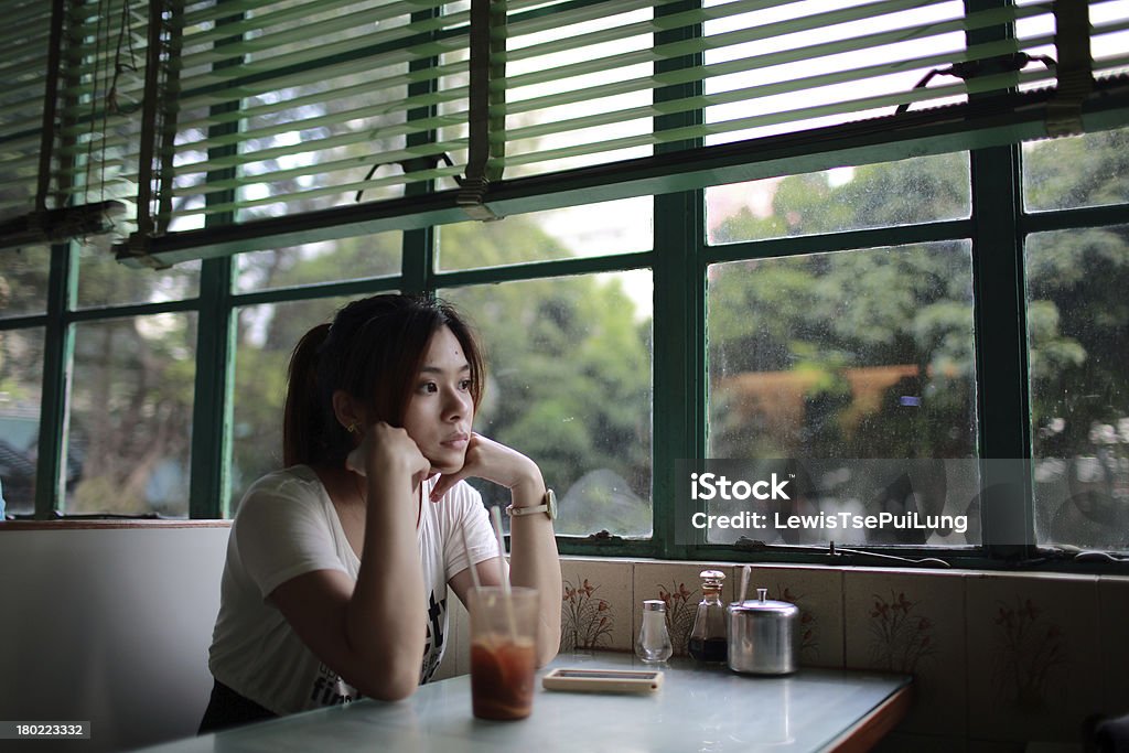 Woman with hands on chin at restaurant table the girl waiting someone so long and feeling bad, She rested her chin on her hand Sadness Stock Photo