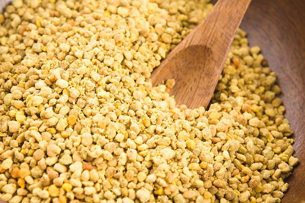 istock Bee pollen in wooden scoop. Nutritional supplement 180223439