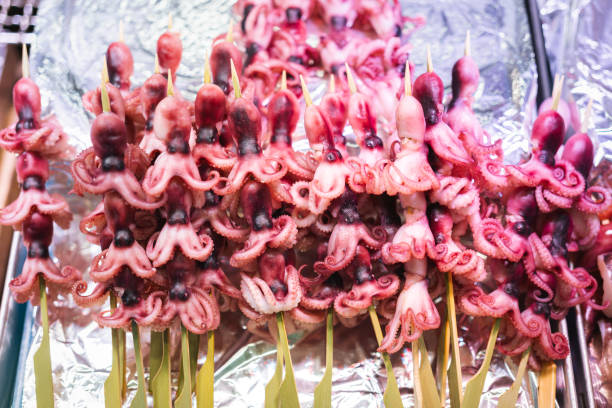 Group of raw octopus meat skewers which is prepared for seafood grilling meal. Seafood object photo, selective focus.