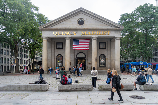 Downtown Boston, this is the Quincy Market, Commercial Street, Boston, Massachusetts. There are tourists and street performers in front of it.
