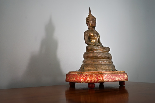 The Buddha image was placed on a shelf for worship. Light shines until it creates beautiful shadows.