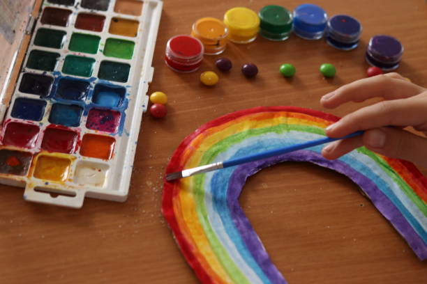 istock children's creativity. drawing a rainbow with watercolors 1802318646