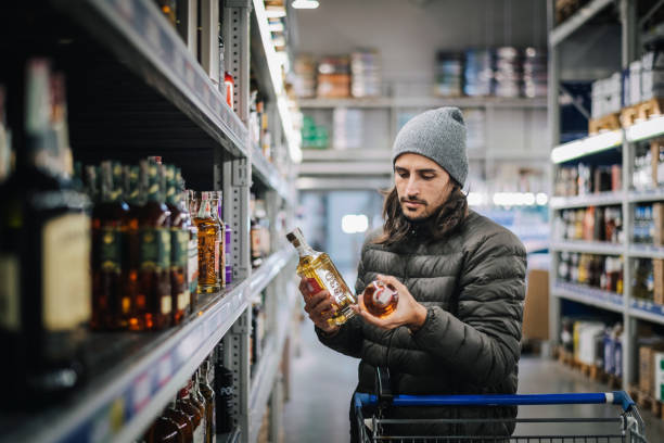 homme dans un magasin d’alcool. - eastern european caucasian one person alcoholism photos et images de collection