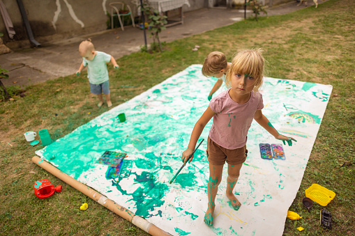 Children playing with watercolors in the backyard