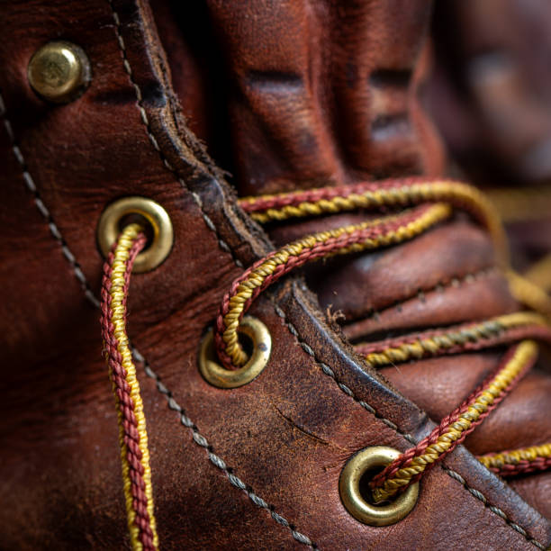 Details of a rustic leather shoe. Leather, eyelets, seam, laces of a used shoe. Details of a rustic leather shoe. Leather, eyelets, seam, laces of a used shoe. eyelet stock pictures, royalty-free photos & images